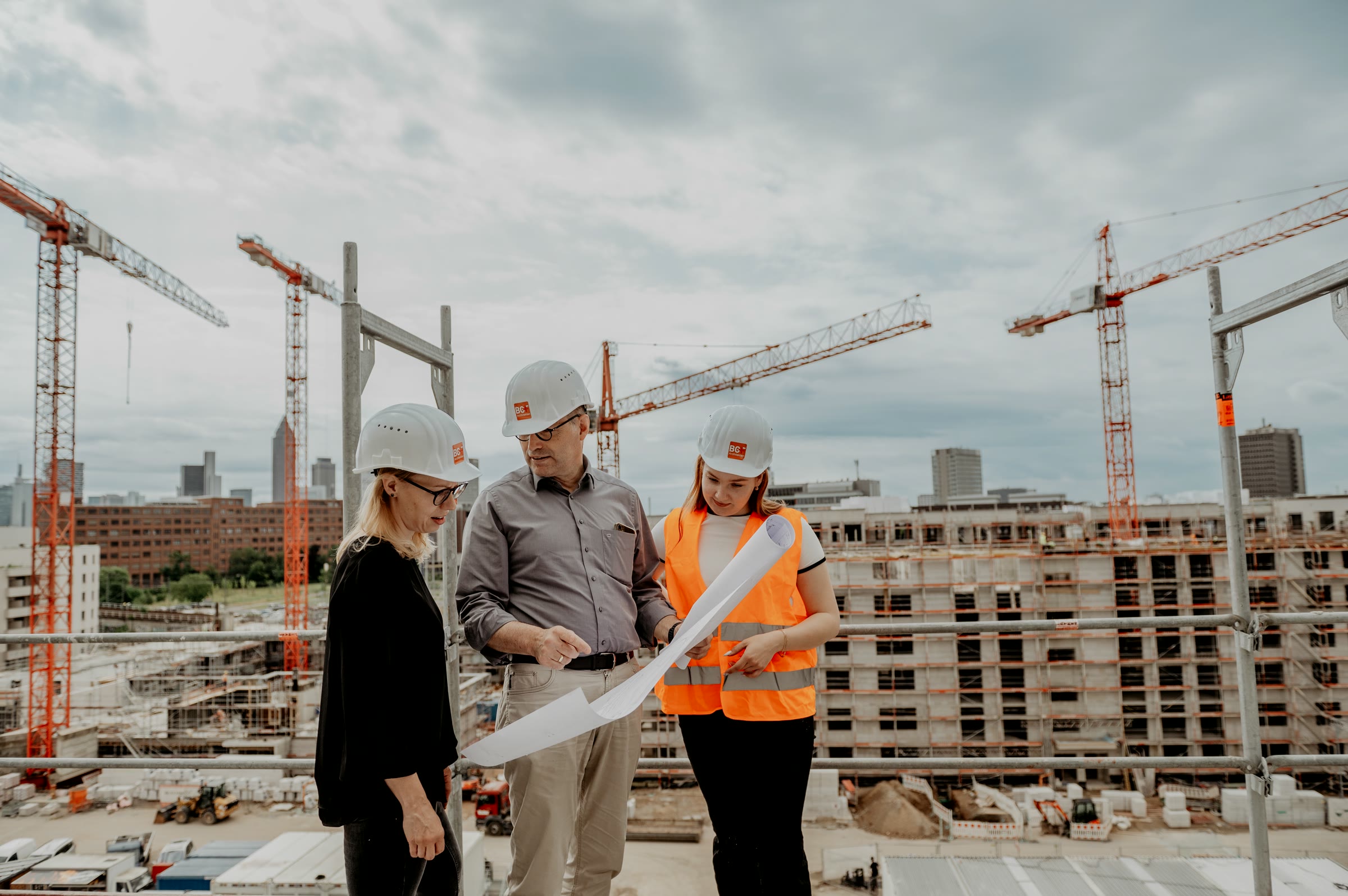 BGF+, Team mit Bauplänen auf der Baustelle