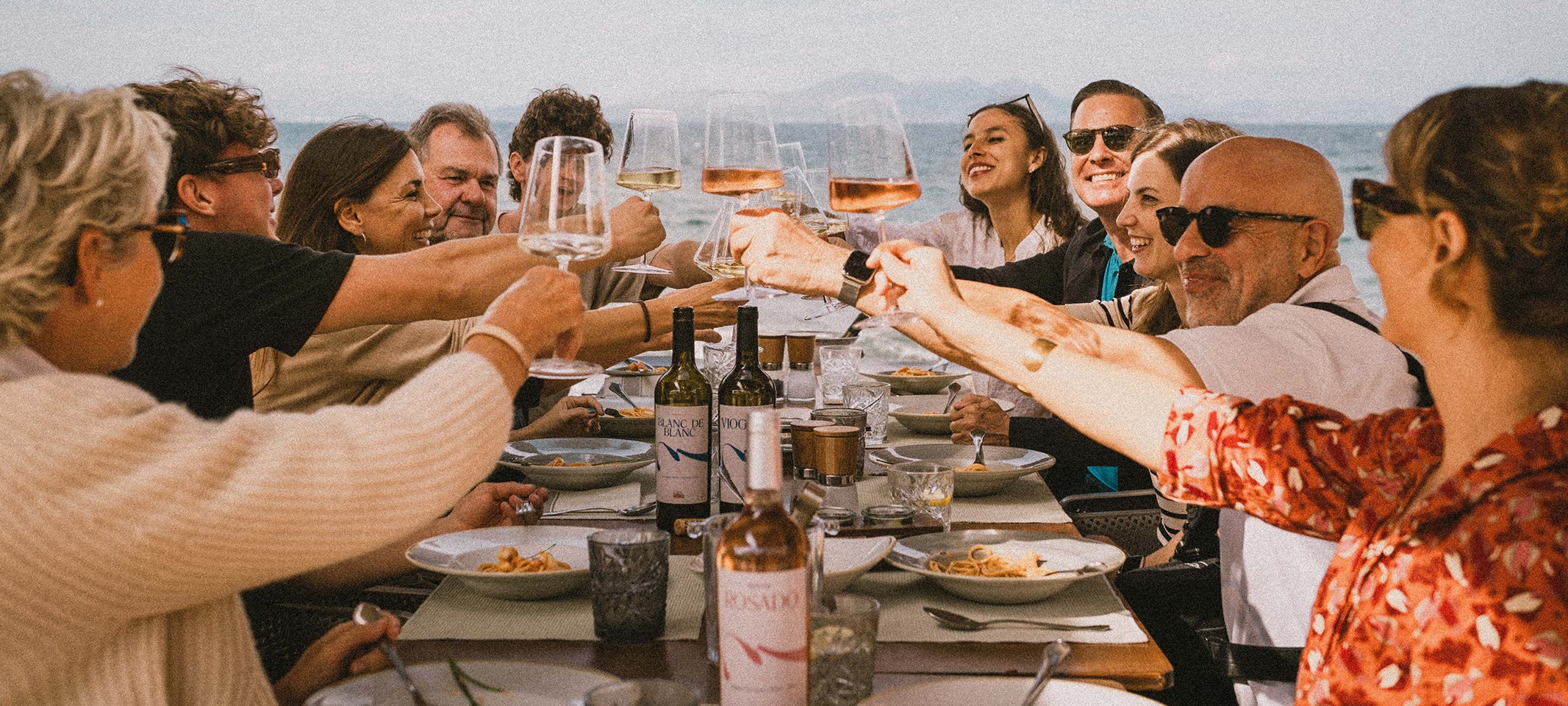 CA’N SORT, Freunde stoßen mit Wein am Meer auf Mallorca an