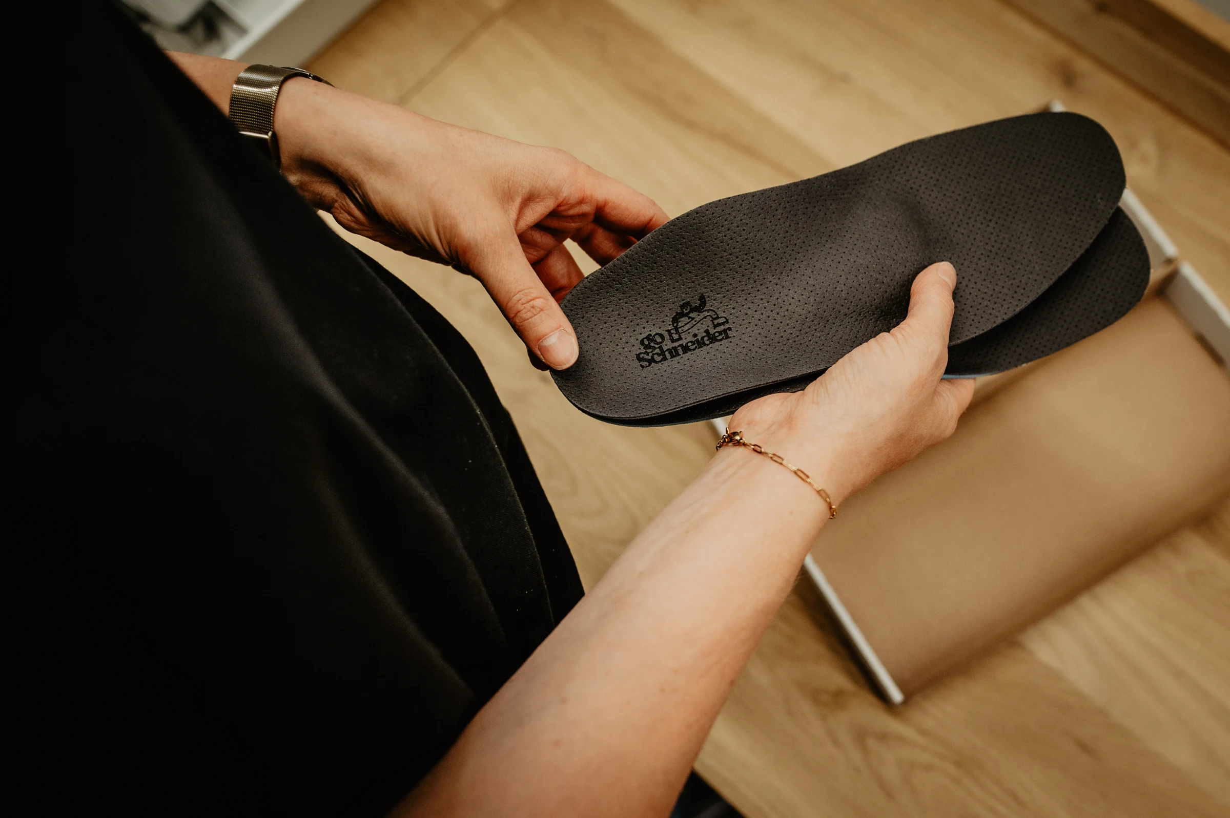 Individuell gefertigte goSchneider Einlage in den Händen – Detail von Material und Branding