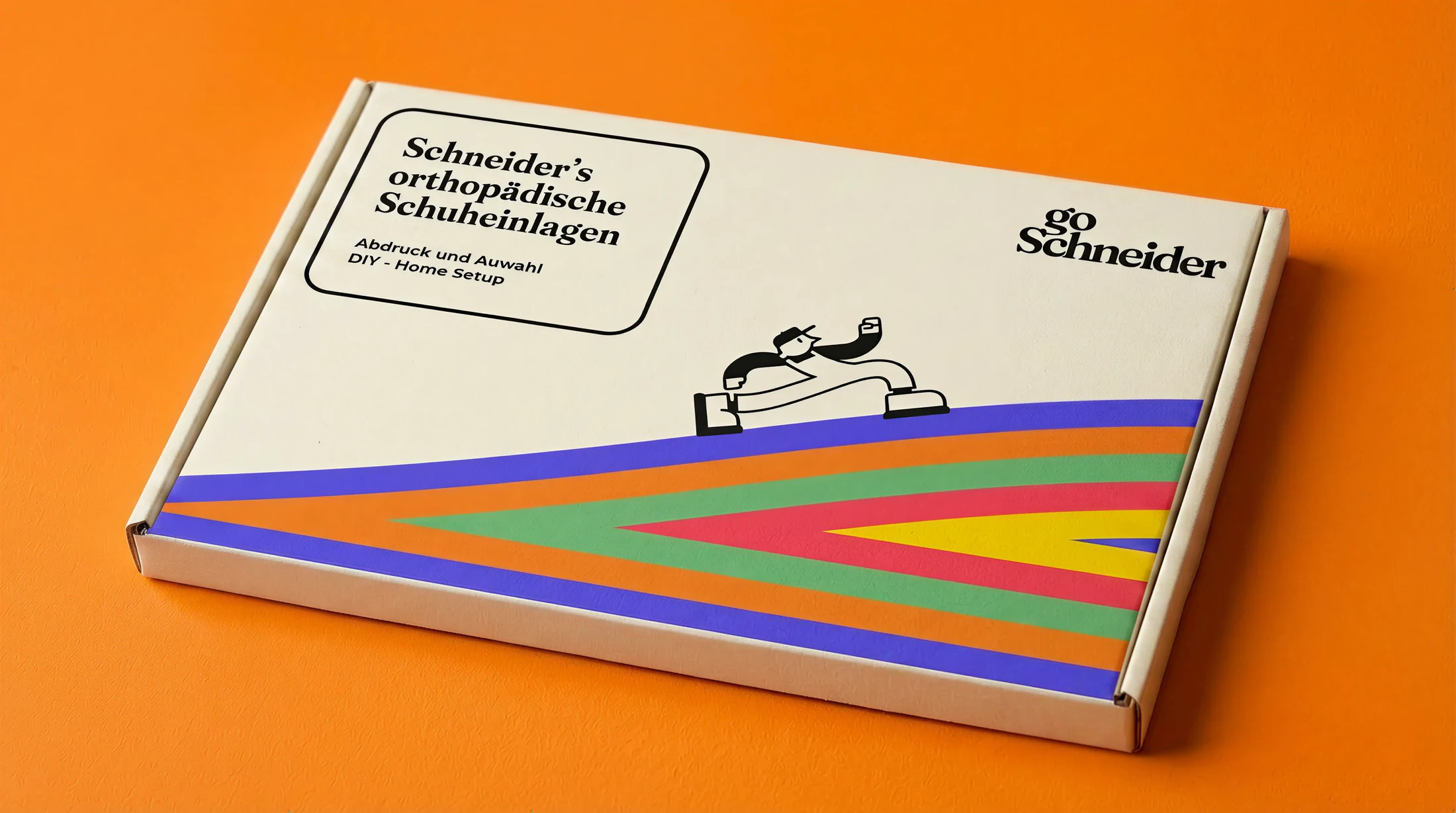 goSchneider Abdruckset-Verpackung mit Markenfigur und farbiger Bodenform auf orangefarbenem Hintergrund