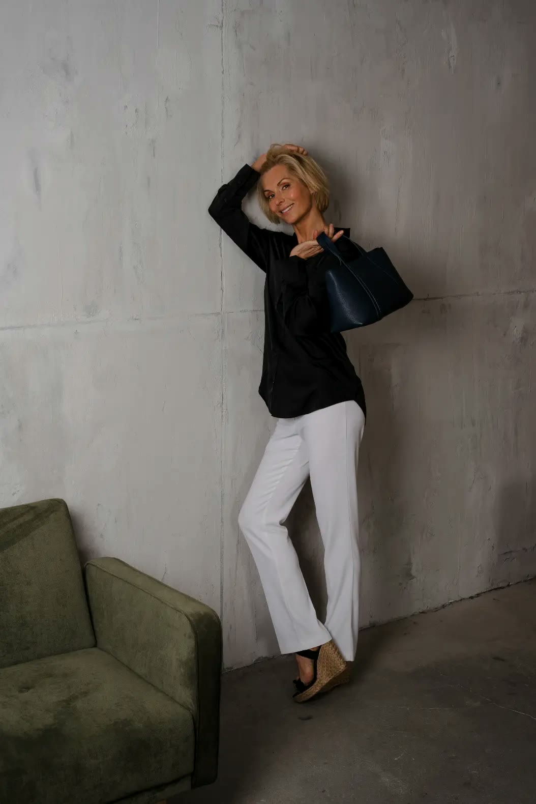 mine mina, Model mit Tasche vor Betonwand