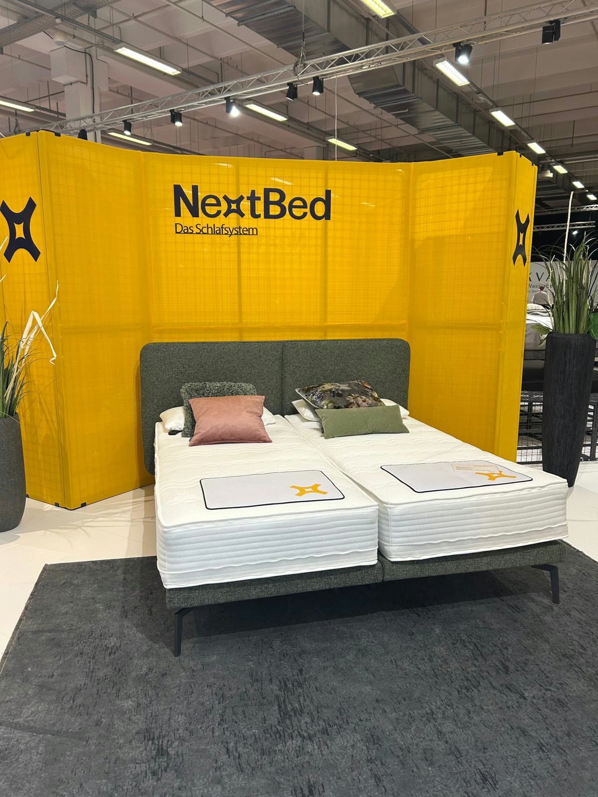 NextBed Messestand mit Bett und Rahmen