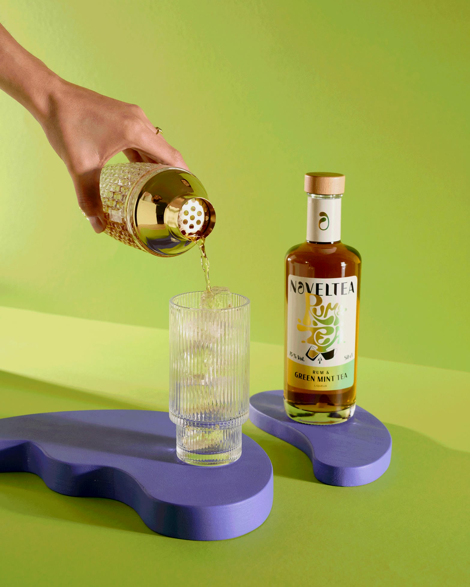Noveltea, Rum & Tea wird aus dem Shaker eingegossen, grüner Grund