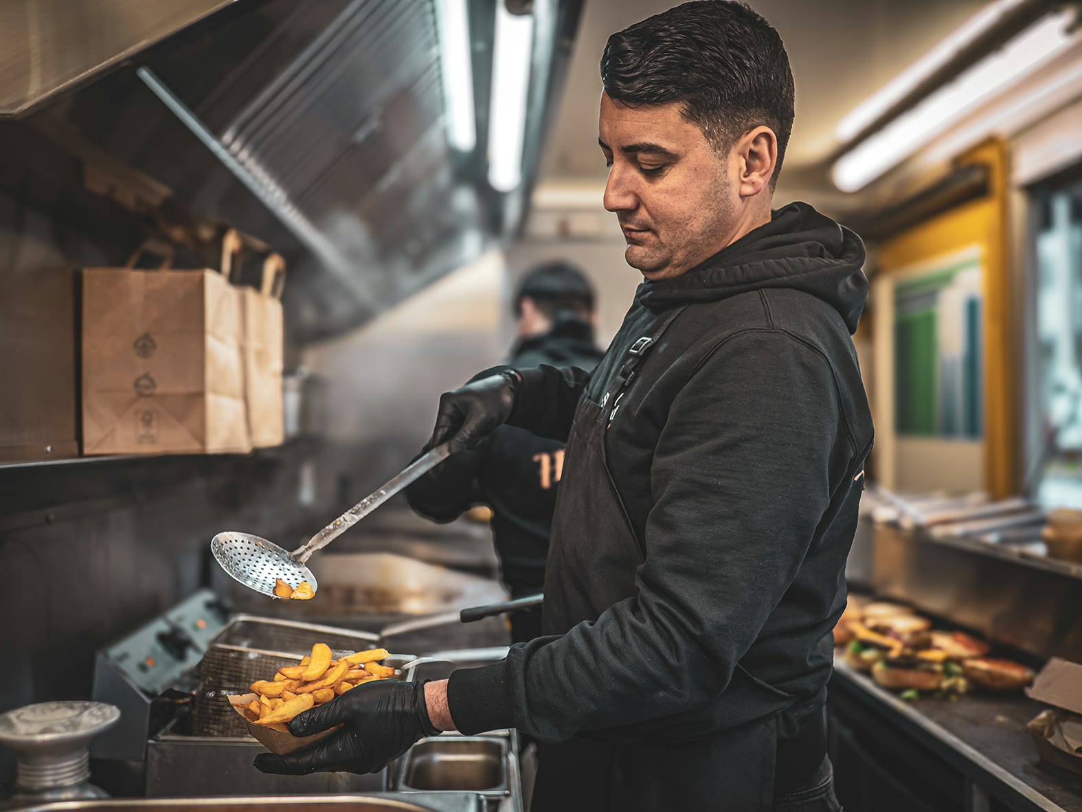 Street Gourmet, Koch mit Pommes im Truck