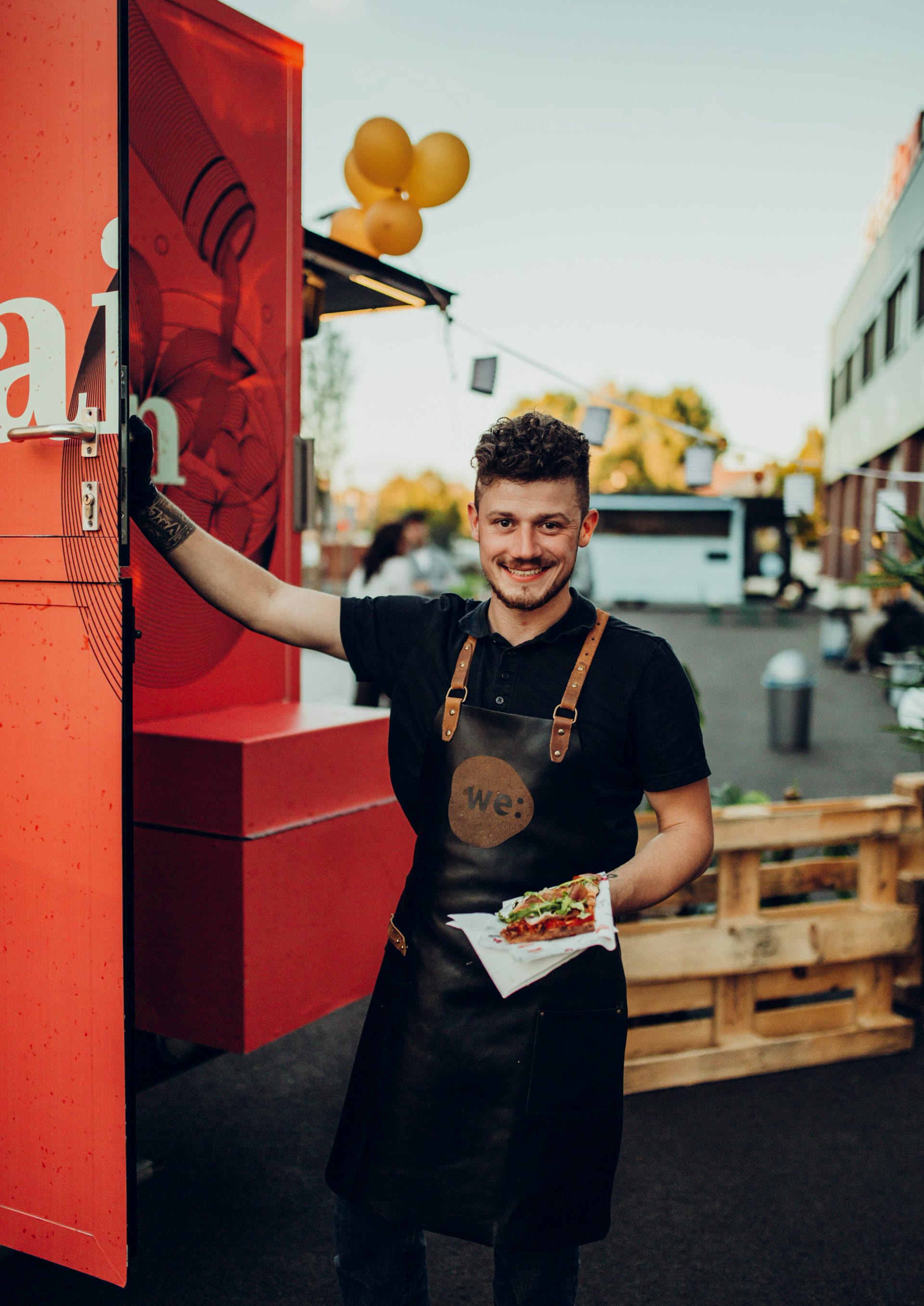 we:celebrate, Koch mit we:-Schürze vor dem Foodtruck