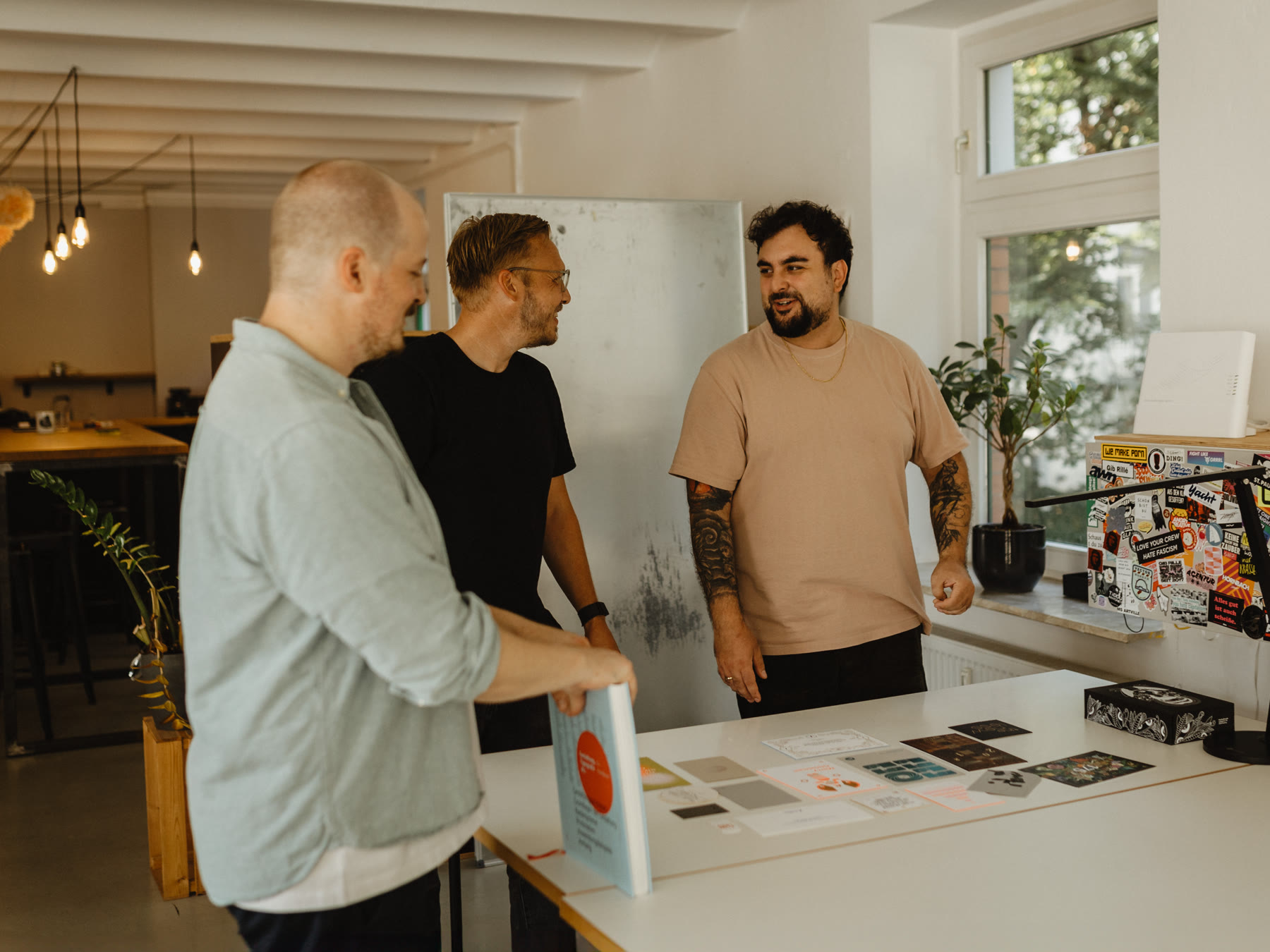 Das Team bespricht Entwürfe am Arbeitstisch